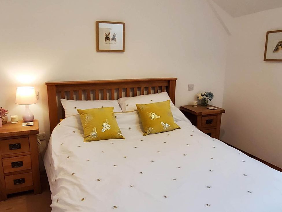 A bedroom with a bed and bedside table at 3 Bedroom Cottage Hot Tub Garden Parking Dunkeswell