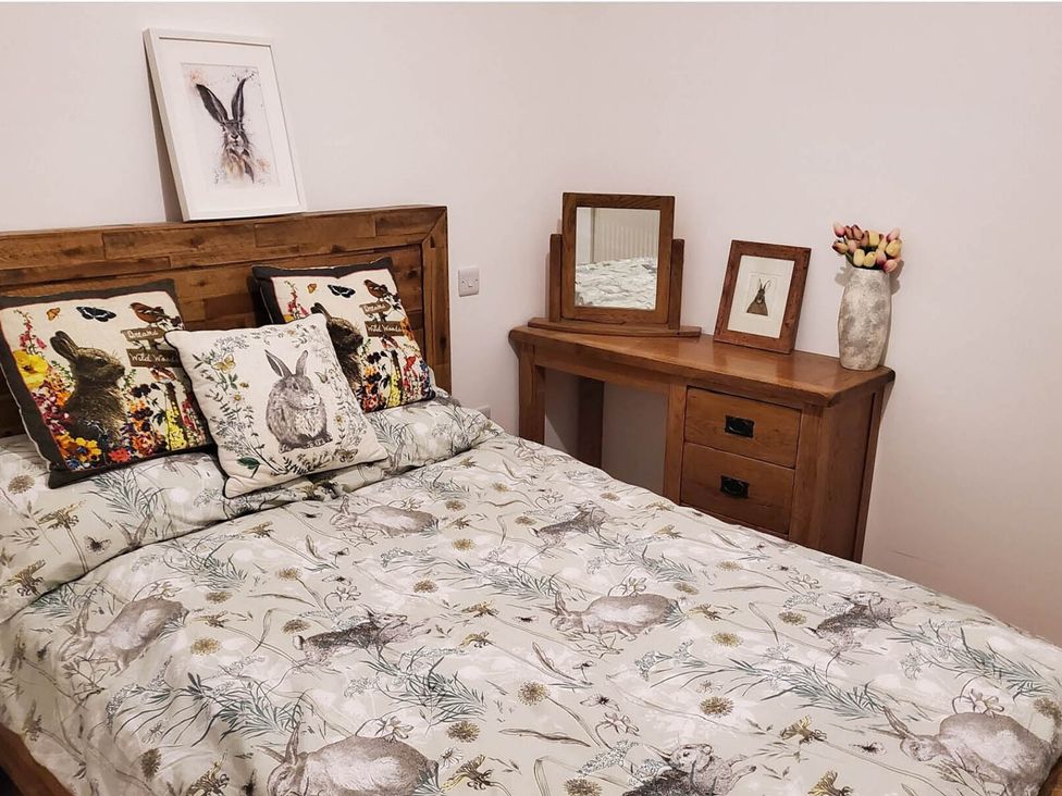 A bedroom with a bed and wooden furniture at 3 Bedroom Cottage Hot Tub Garden Parking Dunkeswell