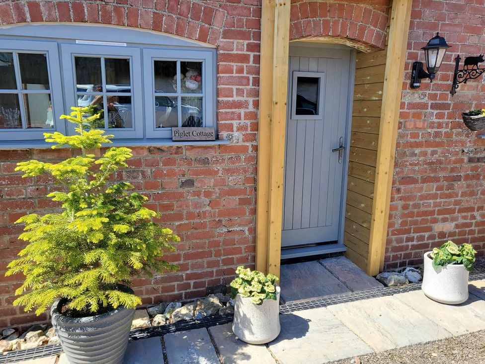 An entryway with a door and plants at Piglet Cottage in Dunkeswell