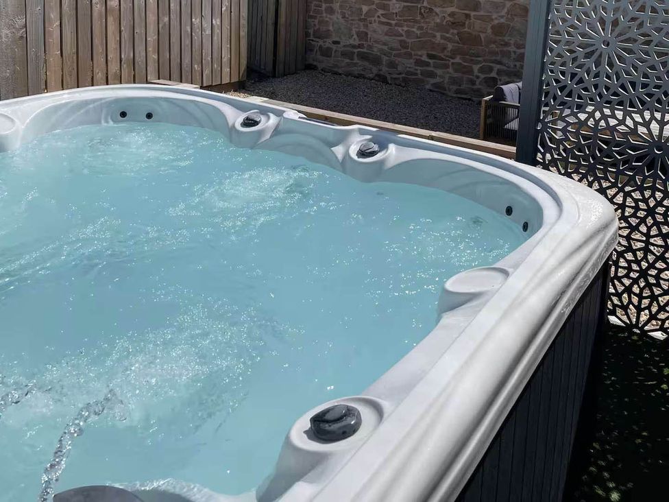 A hot tub with water and jets in an outdoor area at The Old Barn in Forth