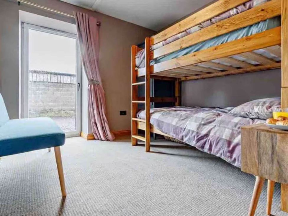 A bedroom with a bunk bed and a sofa at The Old Barn in Forth
