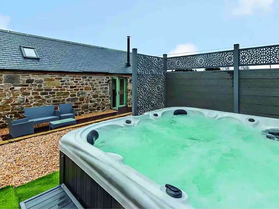 An outdoor area with a hot tub and seating at the property in Forth