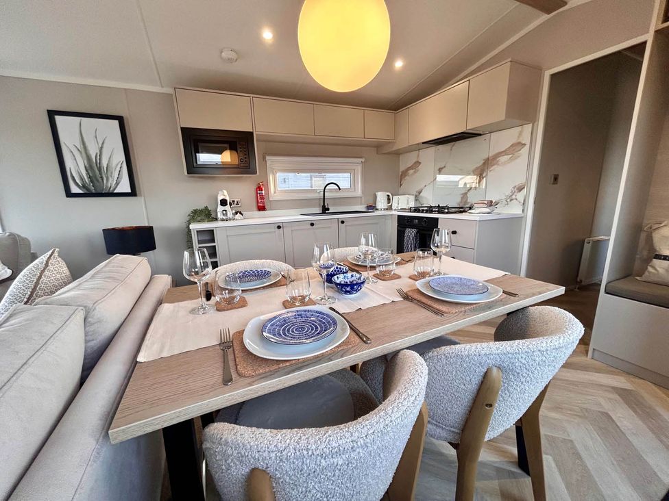 A dining area with a table set for meals at Lovely Holiday Home On Waxham Sands in Great Yarmouth