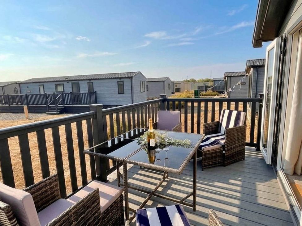 An outdoor patio with a table and chairs at Lovely Holiday Home On Waxham Sands near Sea Palling