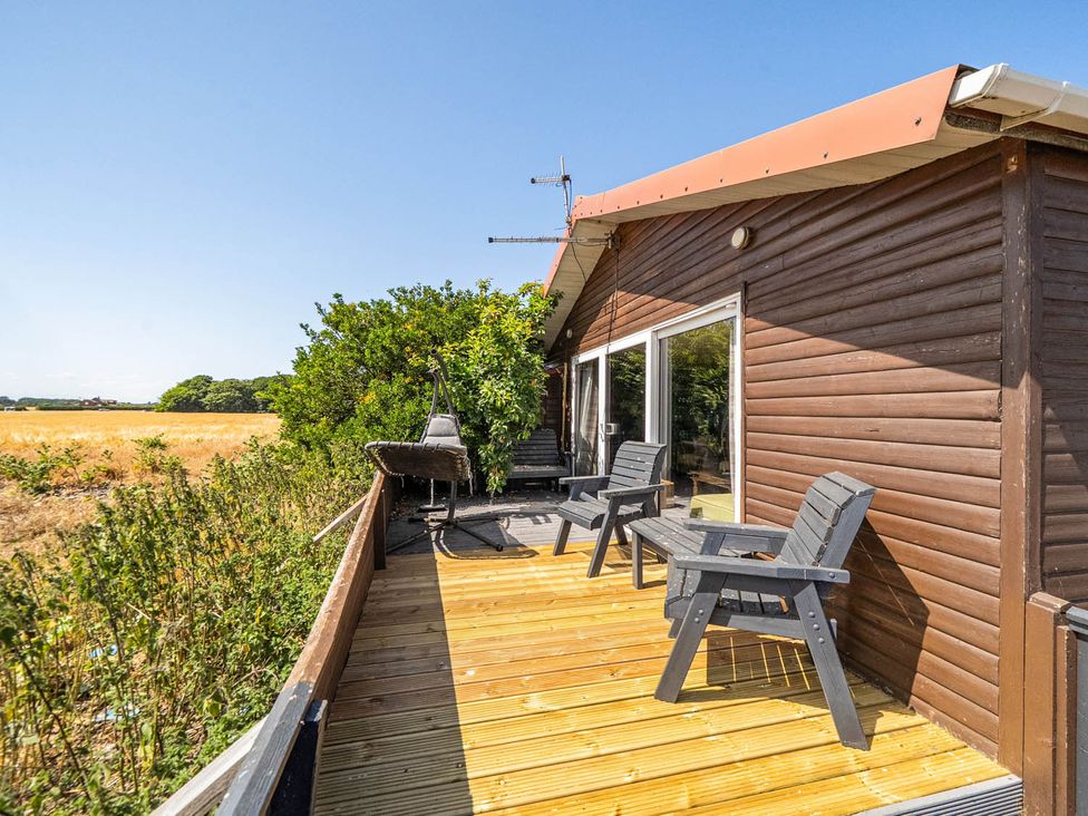 A deck area with chairs and a table at a property
