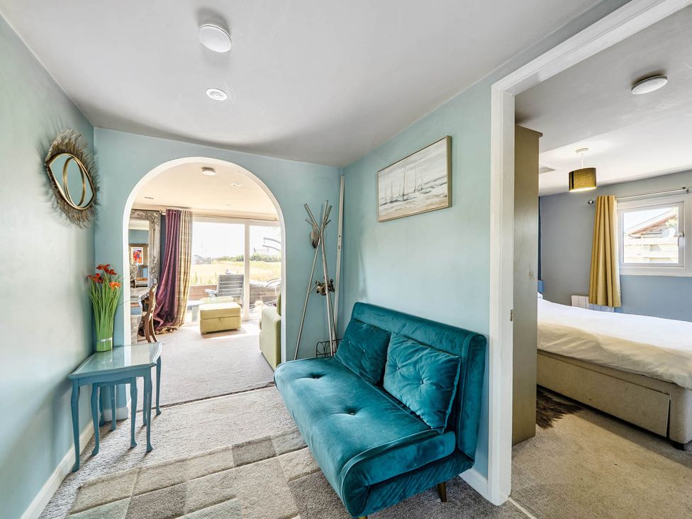 A living room with an archway leading to a bedroom at a property