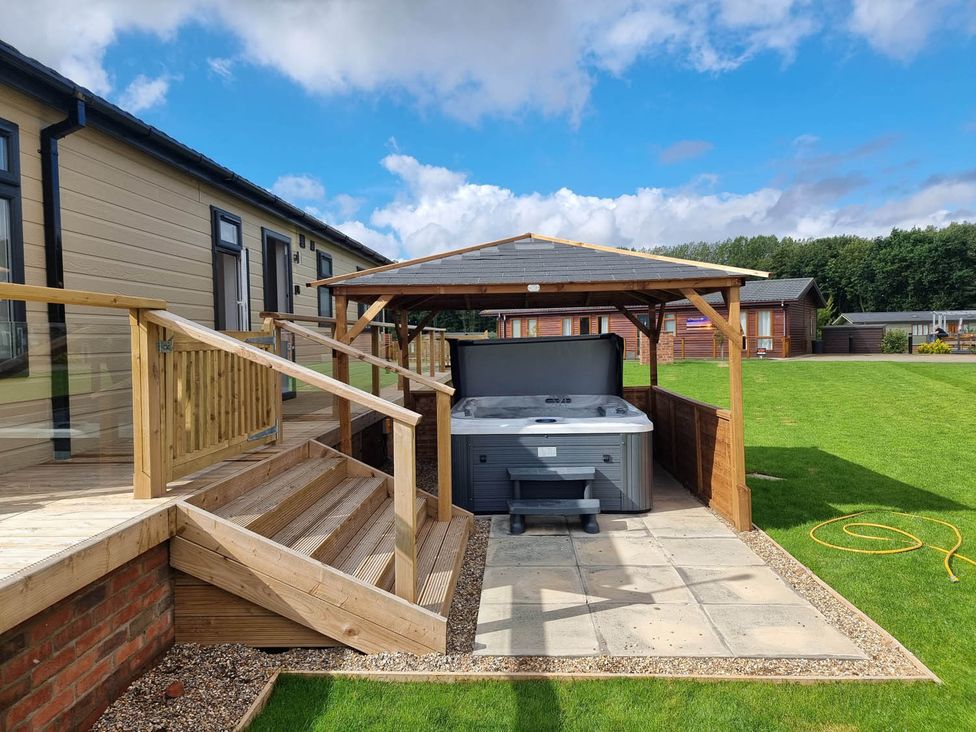 An outdoor area with a hot tub and deck at Pet Friendly 2Bed Luxury Lodge in Routh HotTub Heron Lakes Luxury Lodge Park near Beverley