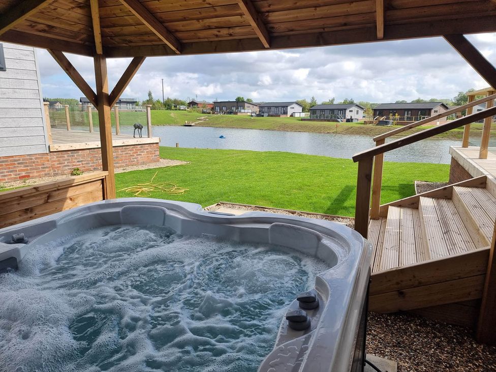 A hot tub with a view of a lake at Pet Friendly 2Bed Luxury Lodge in Routh HotTub Heron Lakes Luxury Lodge Park near Beverley