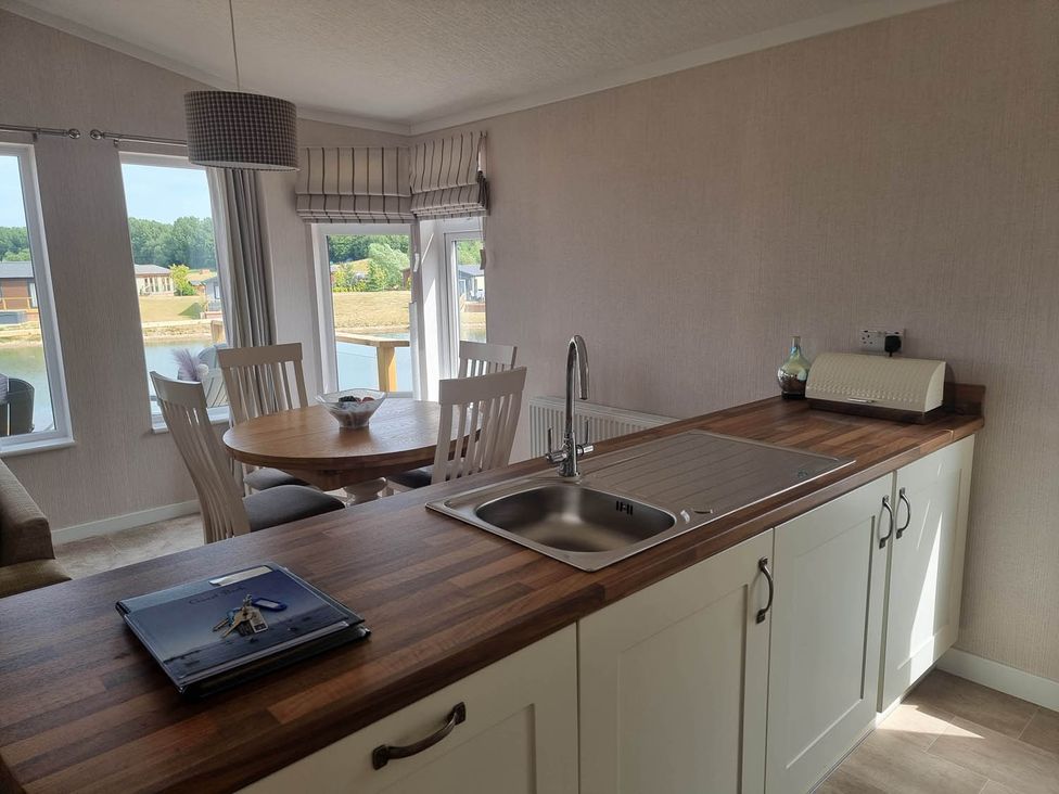 A kitchen with a sink and a dining table at Pet Friendly 2Bed Luxury Lodge in Routh HotTub Heron Lakes Luxury Lodge Park near Beverley