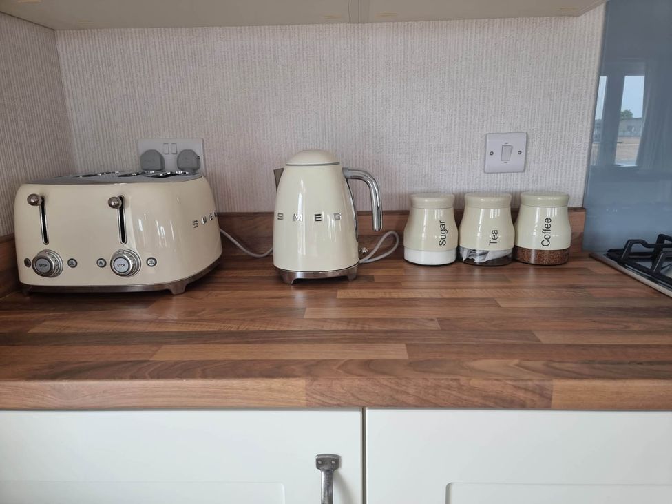 A kitchen countertop with a toaster, kettle, and storage jars labeled sugar, tea, and coffee at Pet Friendly 2Bed Luxury Lodge in Routh HotTub Heron Lakes Luxury Lodge Park near Beverley