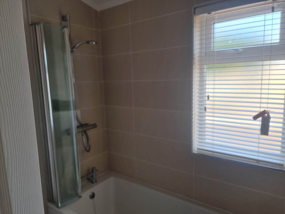 A bathroom with a shower over a bathtub at Pet Friendly 2Bed Luxury Lodge in Routh HotTub Heron Lakes Luxury Lodge Park near Beverley