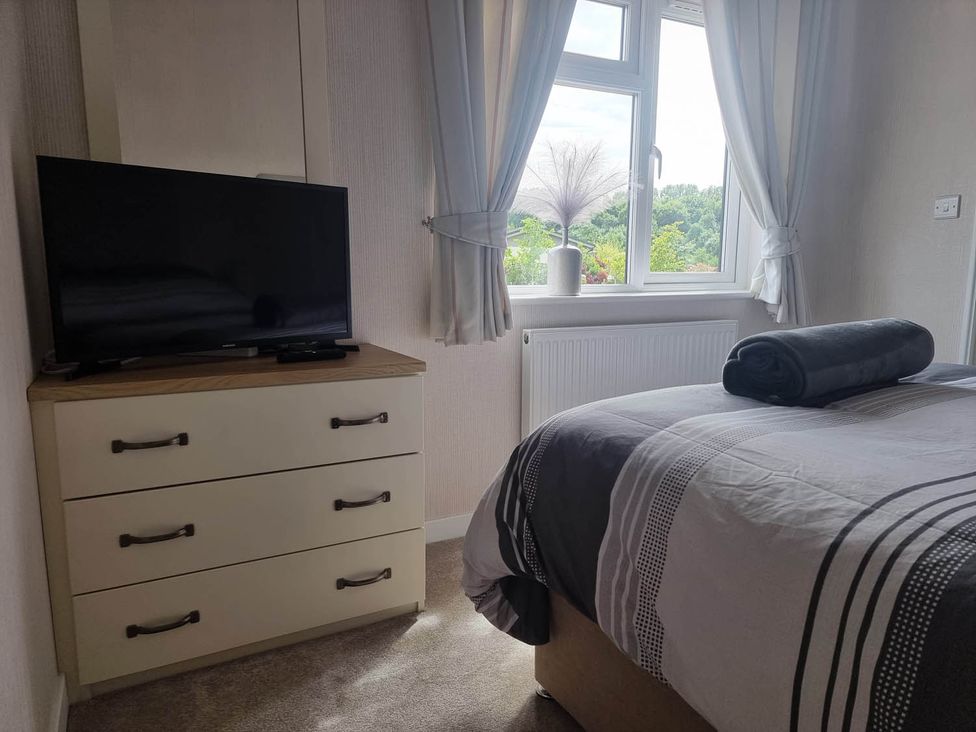 A bedroom with a television and dresser at Pet Friendly 2Bed Luxury Lodge in Routh HotTub near Heron Lakes Luxury Lodge Park
