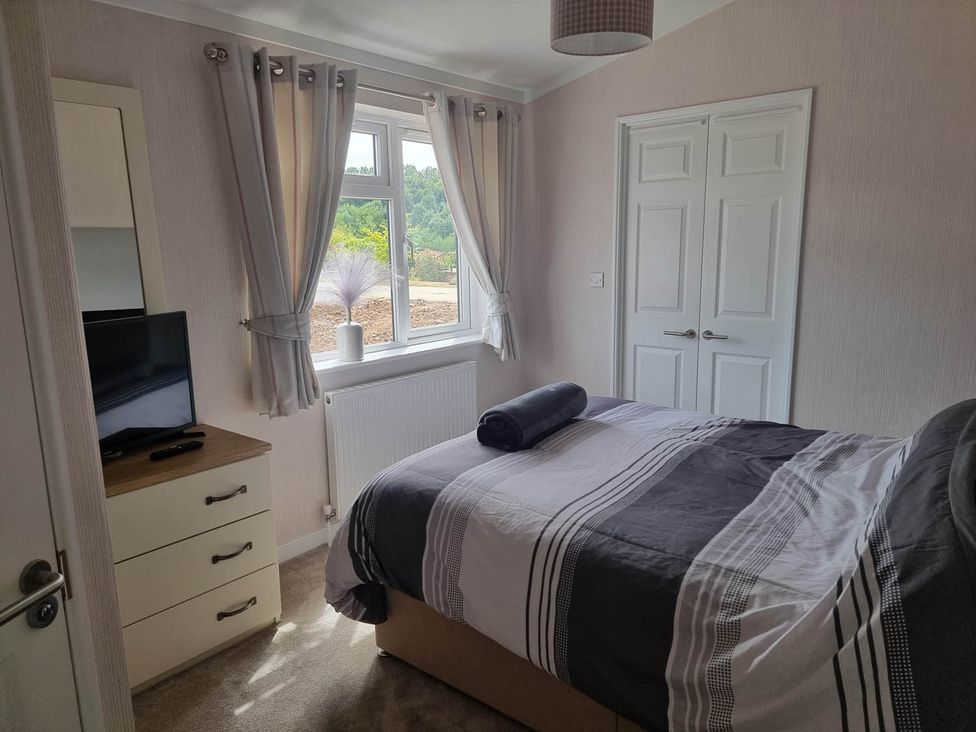 A bedroom with a bed and television at Pet Friendly 2Bed Luxury Lodge in Routh HotTub Heron Lakes Luxury Lodge Park near Beverley