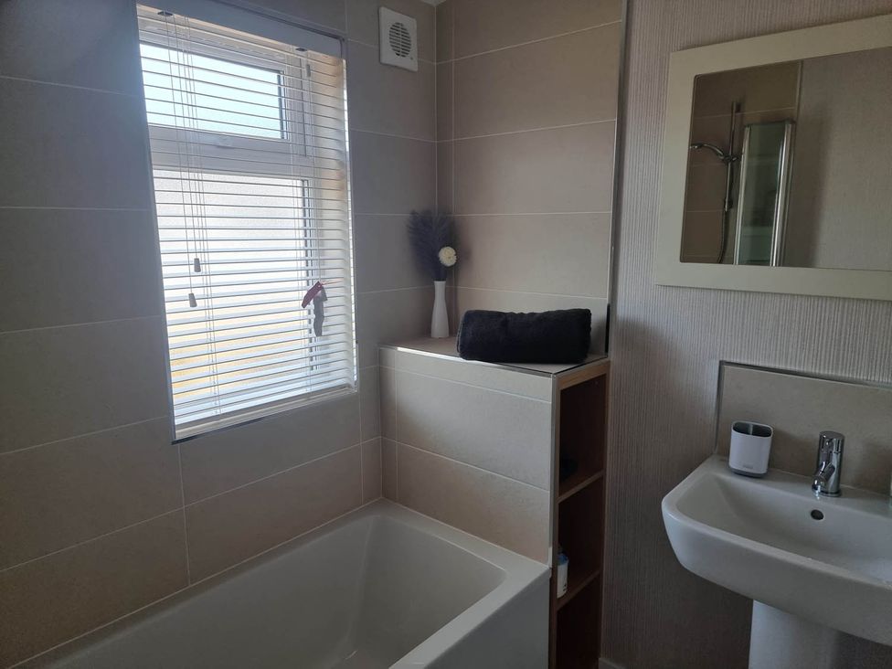 A bathroom with a bathtub and hand basin at Pet Friendly 2Bed Luxury Lodge in Routh HotTub Heron Lakes Luxury Lodge Park near Beverley