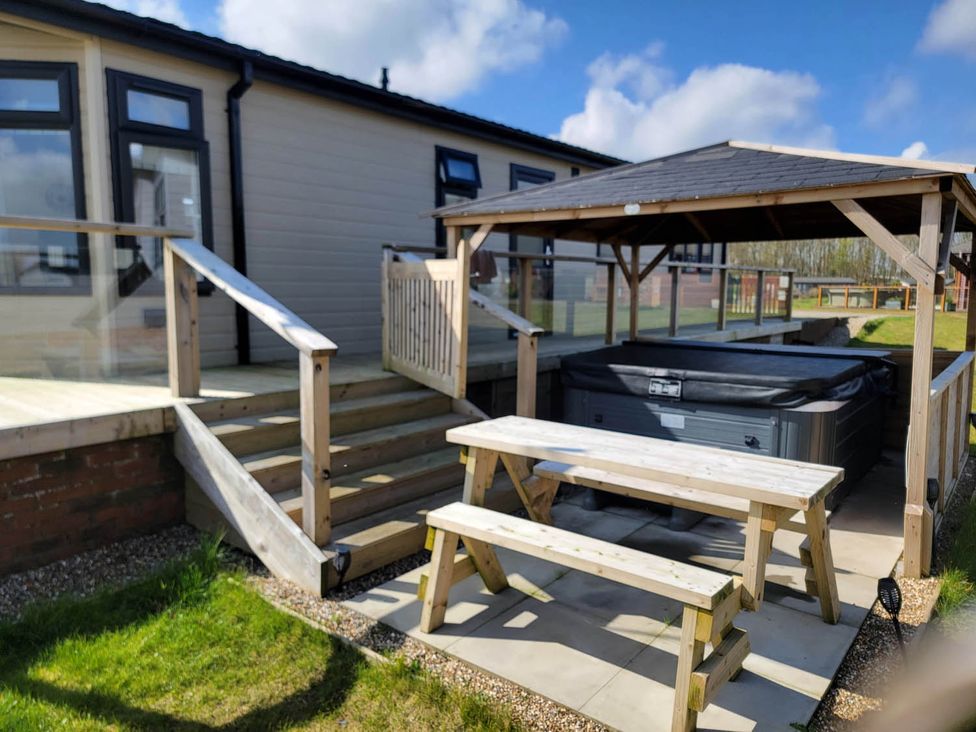 An outdoor area with a hot tub and picnic table at Pet Friendly 2Bed Luxury Lodge in Routh HotTub Heron Lakes Luxury Lodge Park near Beverley