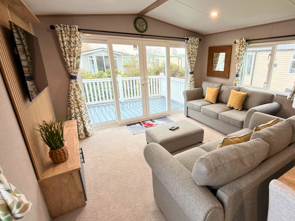 A living room with a sofa and television at Vintage 121 Southview Holiday Park Skegness