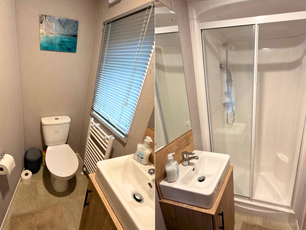 A bathroom with a toilet, sink, and shower at Vintage 121 Southview Holiday Park Skegness