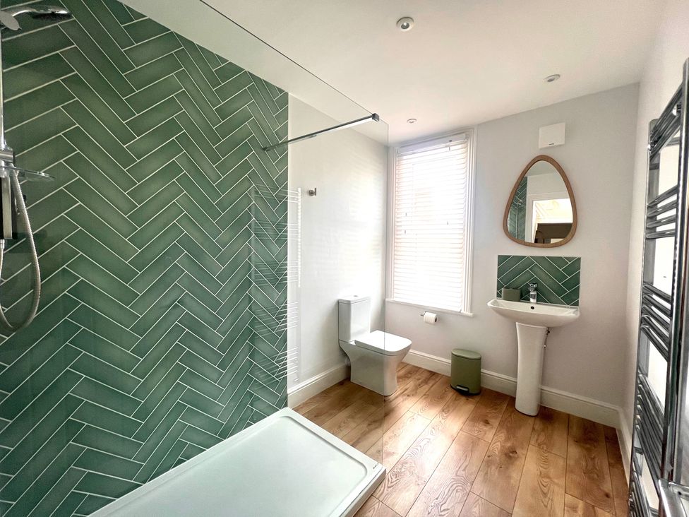 A bathroom with a shower and sink at 4 Bed House Sleeps 8 Garden Pets Near Beach Llandudno