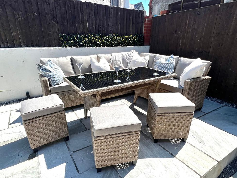 An outdoor seating area with a table and chairs at 4 Bed House Sleeps 8 Garden Pets Near Beach Llandudno