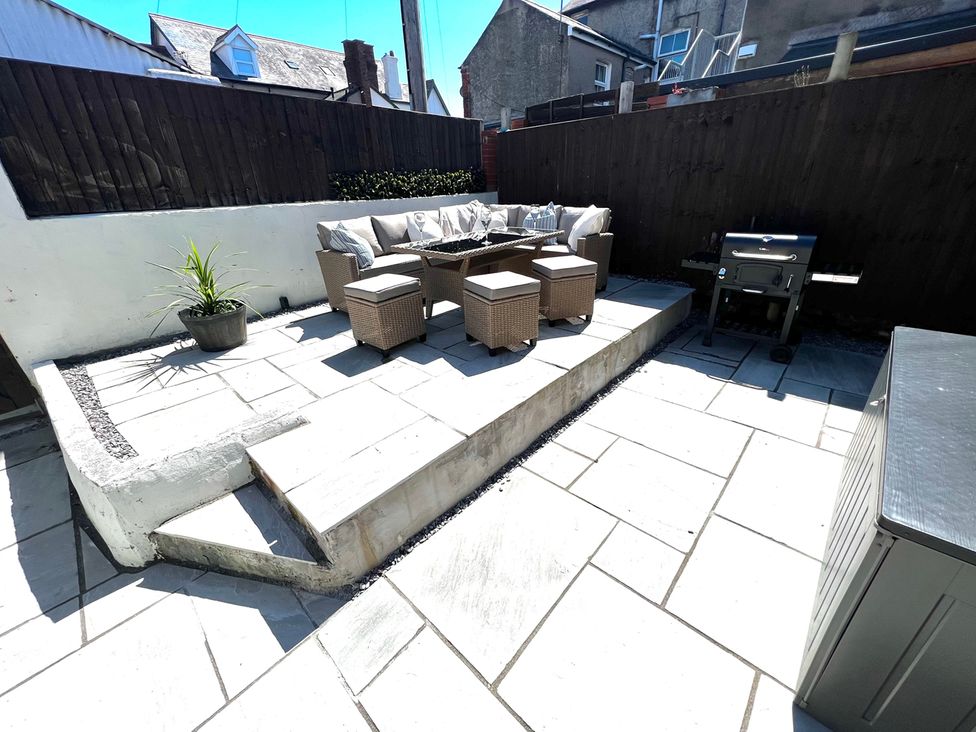 A garden with outdoor seating and a grill at 4 Bed House Sleeps 8 Garden Pets Near Beach, Llandudno
