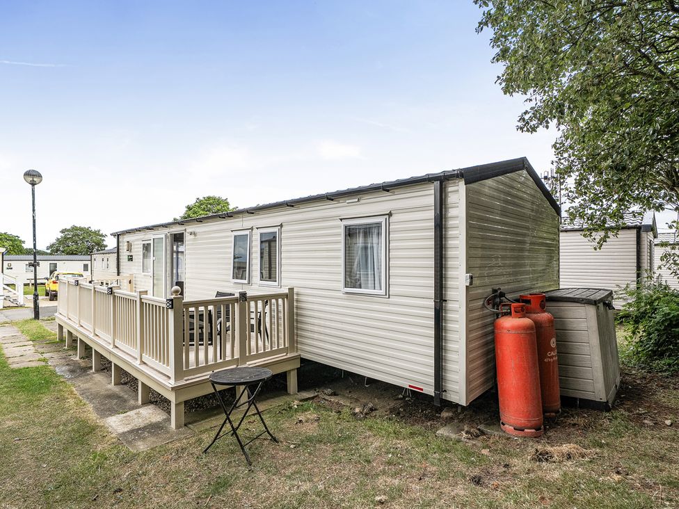 An outdoor view of a caravan with decking and gas cylinders at Primrose Valley 3Bed Caravan Sleeps 8 Pets Ok, Primrose Valley