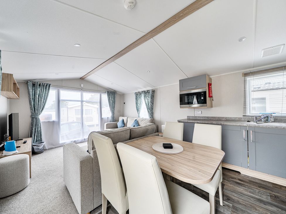 A living room with a sofa and dining table at Primrose Valley 3Bed Caravan Sleeps 8 Pets Ok, Primrose Valley
