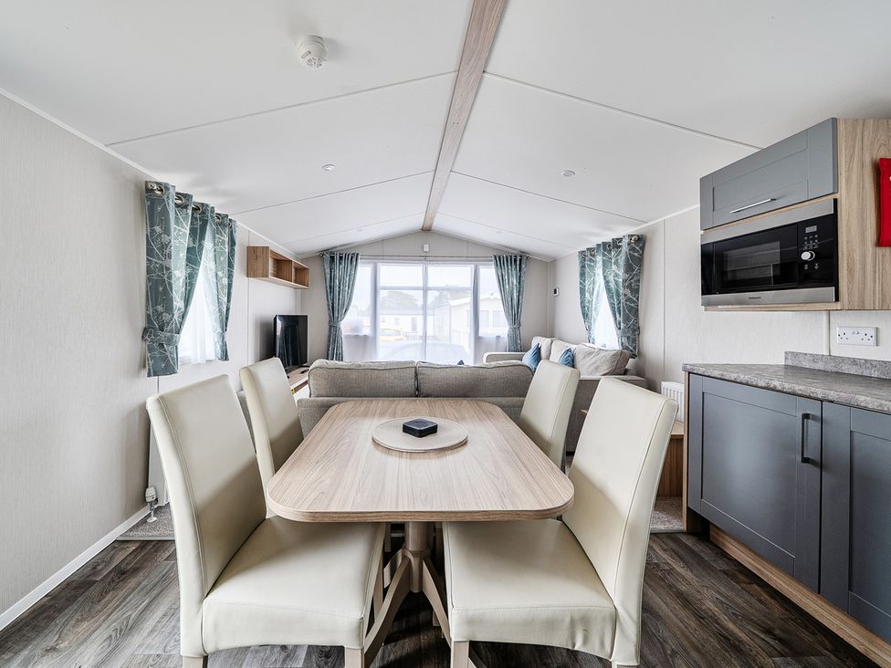 A living room with a dining area and sofa at Primrose Valley 3Bed Caravan Sleeps 8 Pets Ok Primrose Valley