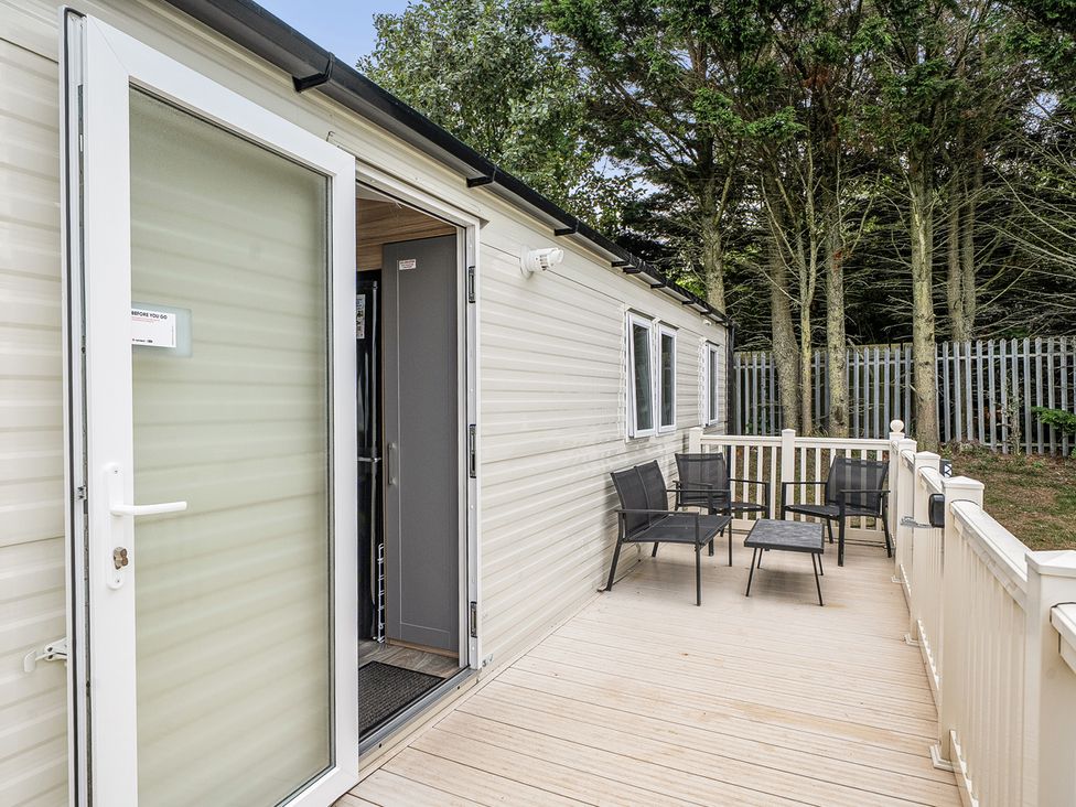 An outdoor deck with chairs and a table at Primrose Valley 3Bed Caravan Sleeps 8 Pets Ok, Primrose Valley