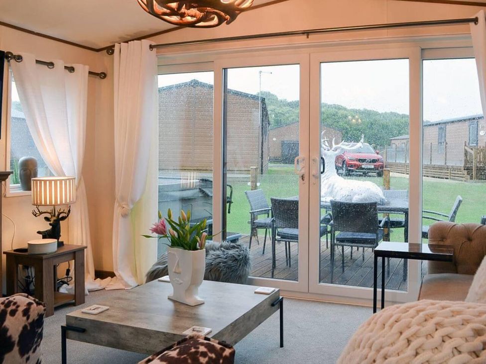 A living room with a table and lamp at Boutique lodge with hot tub sleeps 6 in Bridlington