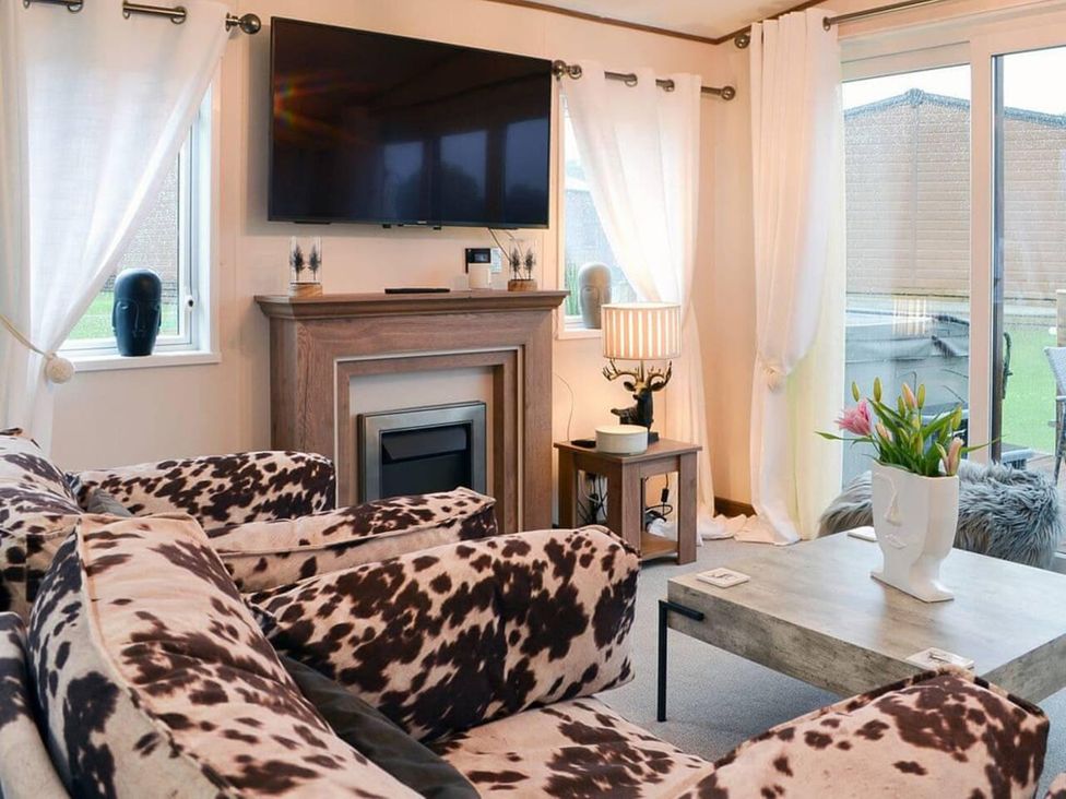 A living room with a sofa and television at Boutique lodge with hot tub sleeps 6 Bridlington