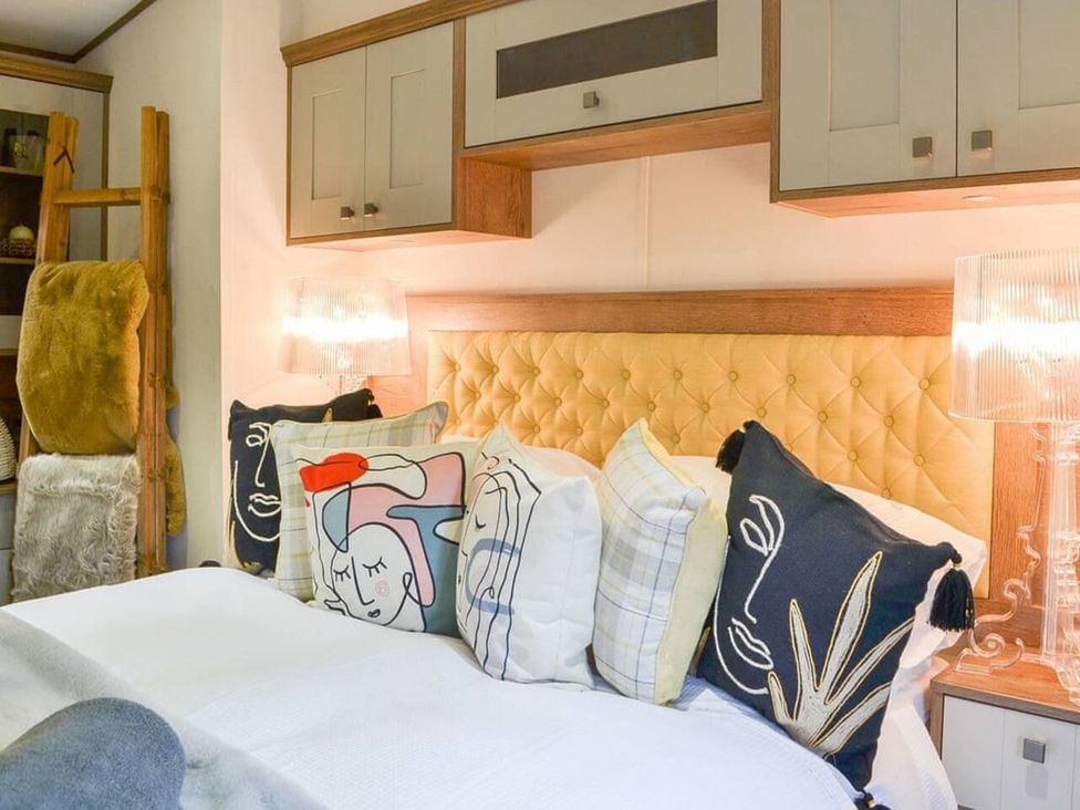 A bedroom with a bed and decorative cushions at Boutique lodge with hot tub sleeps 6 in Bridlington