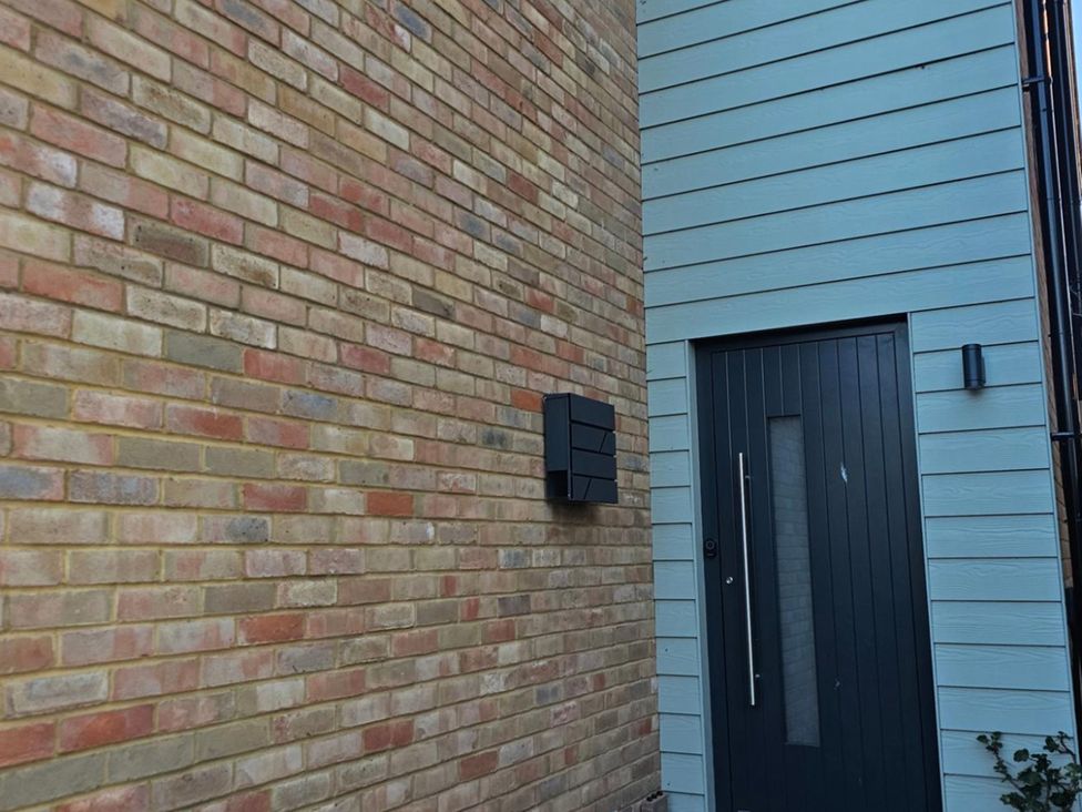 A front door and letterbox on a brick wall at 5 Bed Sleeps 7 New Build Detached Property in Monkton near Minster