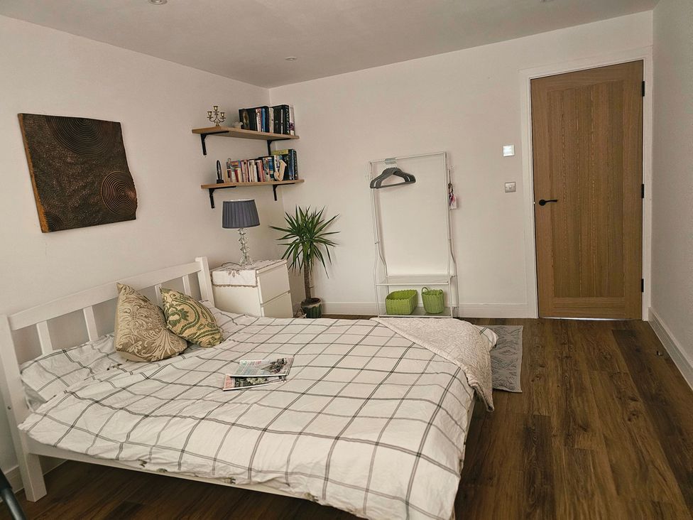 A bedroom with a bed and bookshelf at 5 Bed Sleeps 7 New Build Detached Property in Monkton near Minster