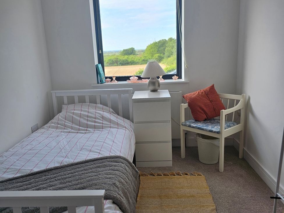 A bedroom with a bed, nightstand, lamp and chair at 5 Bed Sleeps 7 New Build Detached Property in Monkton near Minster