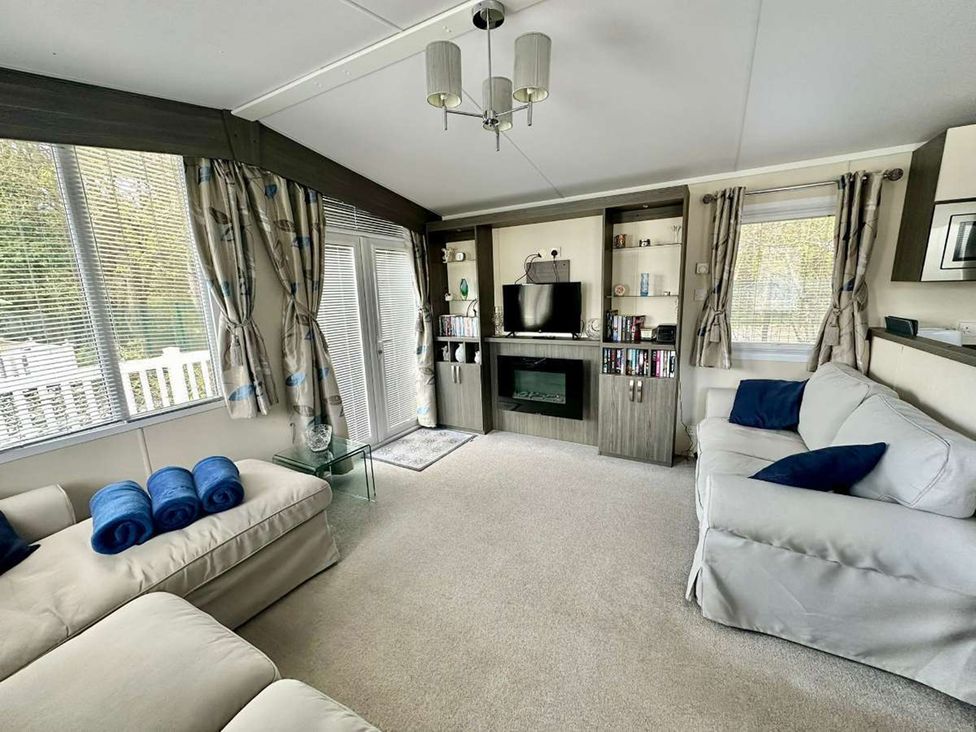A living room with a sofa and television at 2Bed Ringwood Cabin incl Park Pass SelfCheckin Saint Leonards near Ferndown