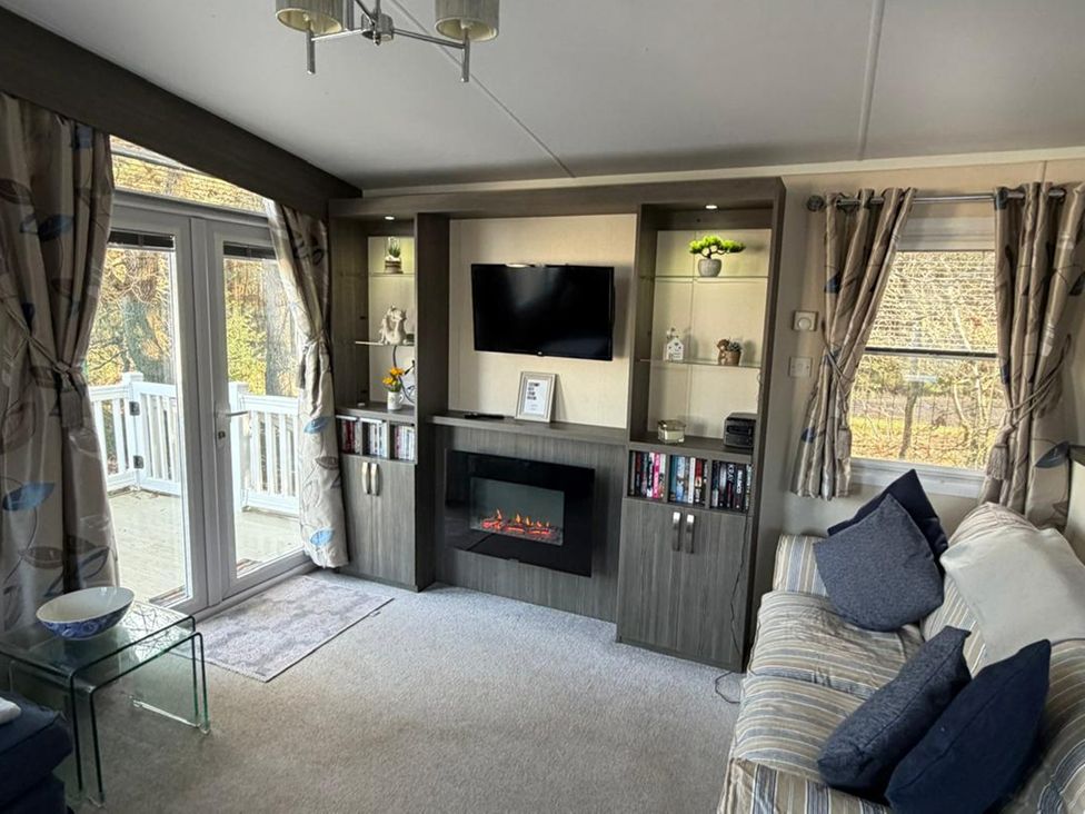 A living room with a TV and fireplace at 2Bed Ringwood Cabin incl Park Pass SelfCheckin in Saint Leonards near Ferndown