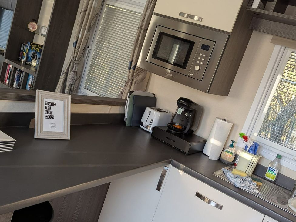 A kitchen with appliances and a framed note at 2Bed Ringwood Cabin incl Park Pass SelfCheckin Saint Leonards near Ferndown