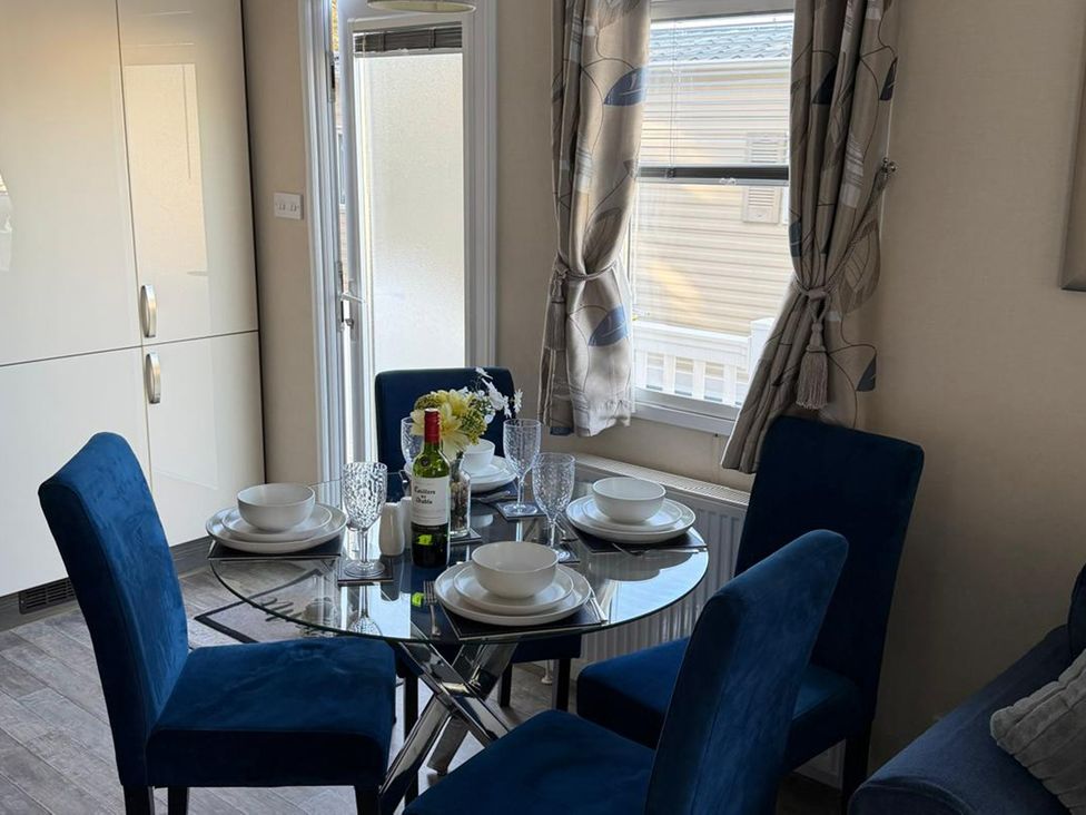A dining area with a table set for dinner at 2Bed Ringwood Cabin incl Park Pass SelfCheckin in Saint Leonards near Ferndown