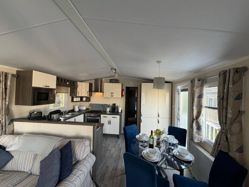 A living room and kitchen area with dining table and chairs at 2Bed Ringwood Cabin incl Park Pass SelfCheckin Saint Leonards near Ferndown