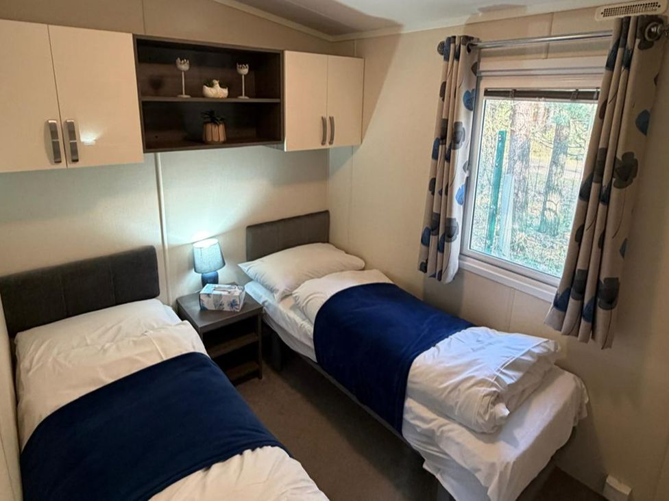 A bedroom with two single beds and a nightstand at 2Bed Ringwood Cabin incl Park Pass SelfCheckin Saint Leonards near Ferndown