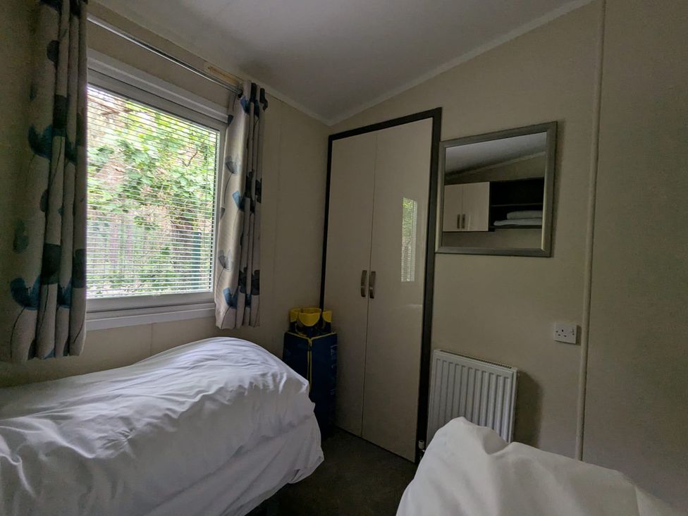 A bedroom with a bed and window at 2Bed Ringwood Cabin incl Park Pass SelfCheckin, Saint Leonards near Ferndown