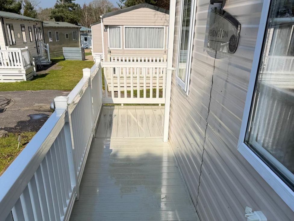 A deck with railing and entrance to a cabin at 2Bed Ringwood Cabin incl Park Pass SelfCheckin Saint Leonards near Ferndown