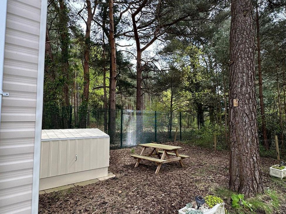 An outdoor area with a picnic table and a shed at 2Bed Ringwood Cabin incl Park Pass SelfCheckin, Saint Leonards near Ferndown