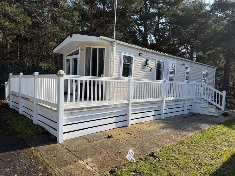 A cabin with a deck and railing at 2Bed Ringwood Cabin incl Park Pass SelfCheckin in Saint Leonards near Ferndown