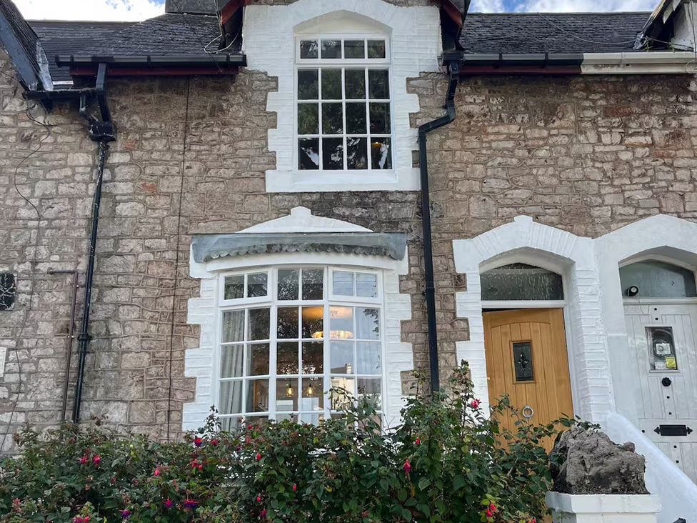 An exterior view of a house with windows and a wooden door at Charming 3Bed Cottage Private Garden Parking in Torquay