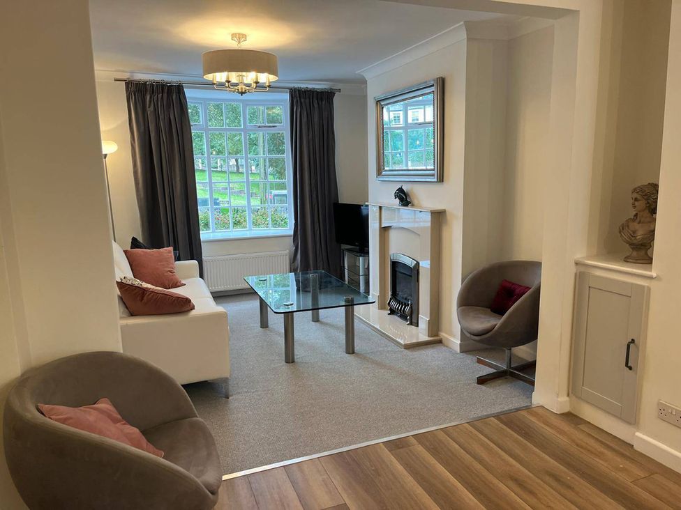 A living room with a sofa, coffee table, and fireplace at Charming 3Bed Cottage Private Garden Parking in Torquay