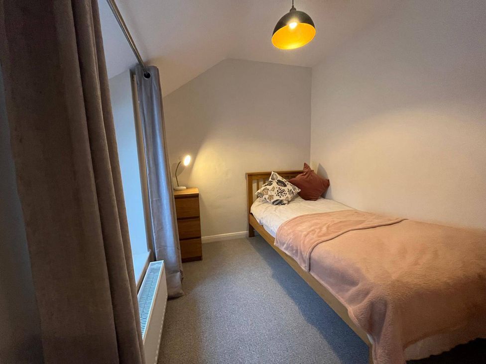 A bedroom with a bed and a lamp at Charming 3Bed Cottage  Private Garden Parking in Torquay