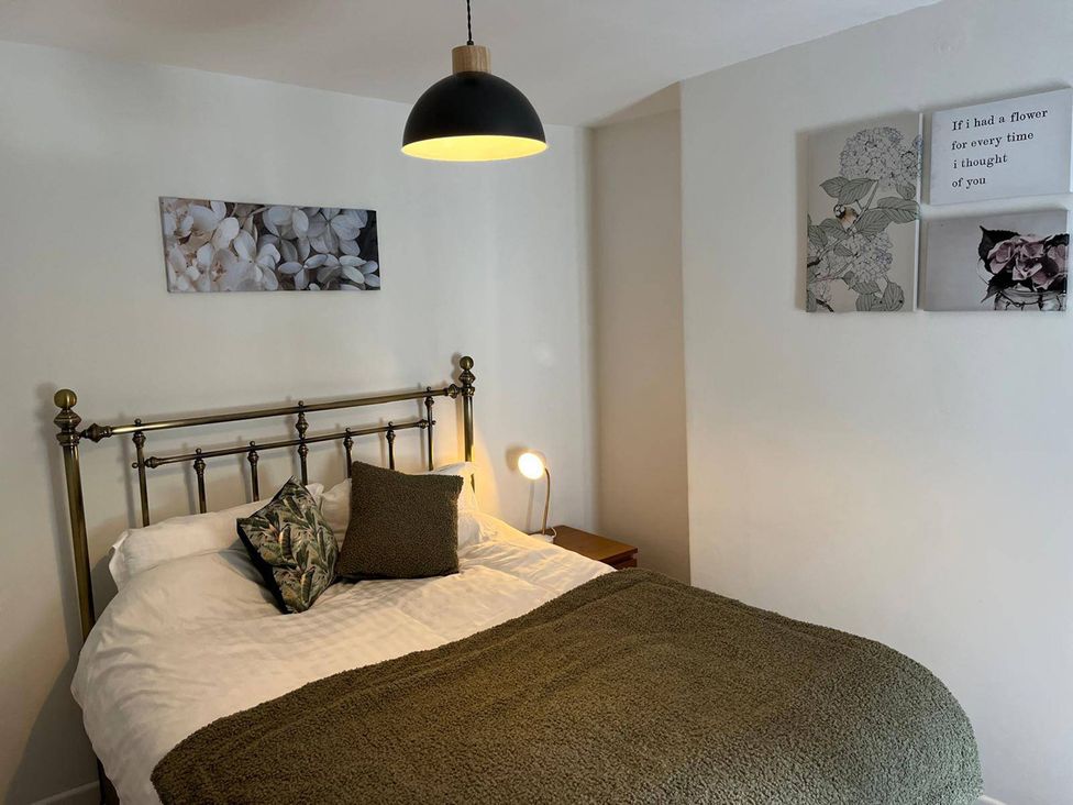 A bedroom featuring a bed with decorative pillows at Charming 3Bed Cottage Private Garden Parking in Torquay