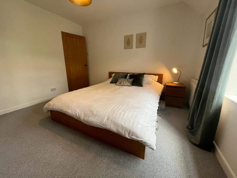A bedroom with a bed and nightstand at Charming 3Bed Cottage Private Garden Parking Torquay