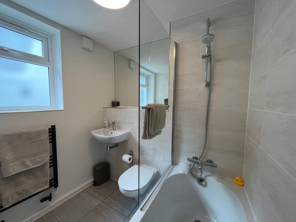 A bathroom with a bathtub and shower at Charming 3Bed Cottage Private Garden Parking in Torquay